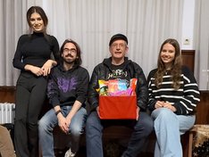 Die Mitglieder der Basisgruppe sitzen mit Geschenk im Jugendtreff